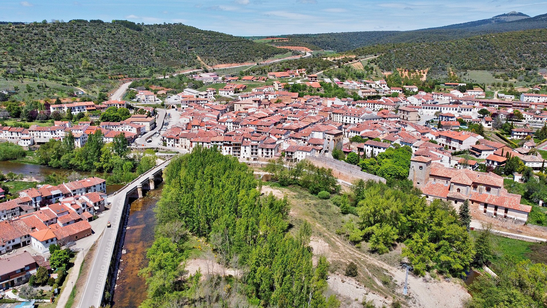 Vista aérea de Covarrubias, su puente y el Arlanza. Fuente: Wikicommons.